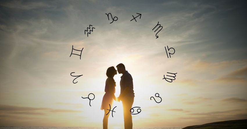 Silhouetted couple standing together beneath floating zodiac symbols and soft golden light